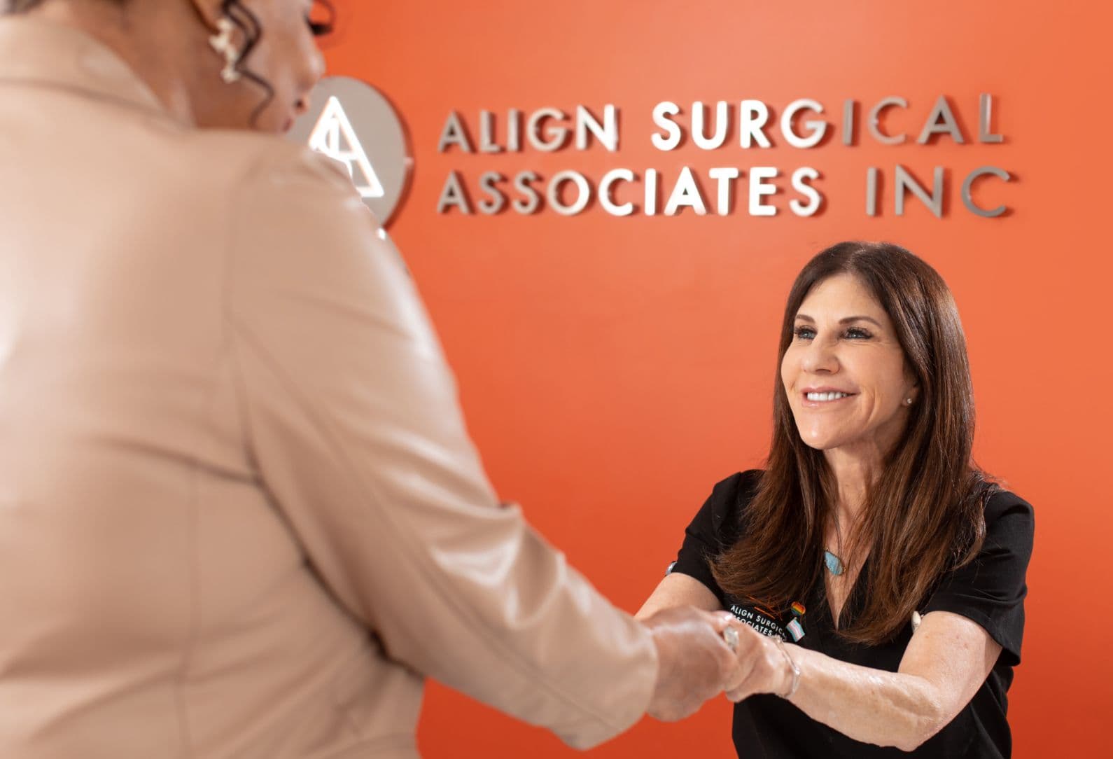Align Surgical Associates team member welcoming a patient at the clinic reception desk