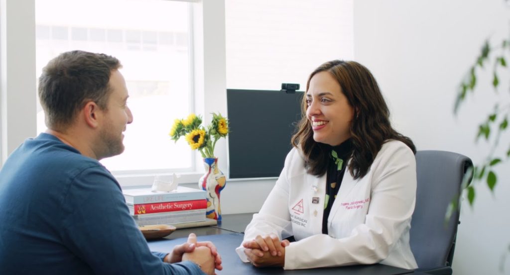 Photo of Dr. Breanna Jedrzejewski speaking to a male patient