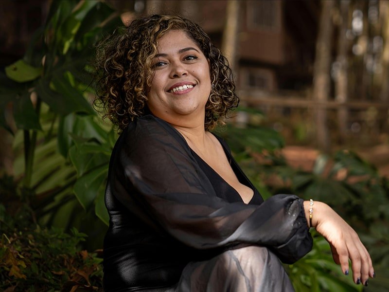 Smiling woman against a backdrop of foliage