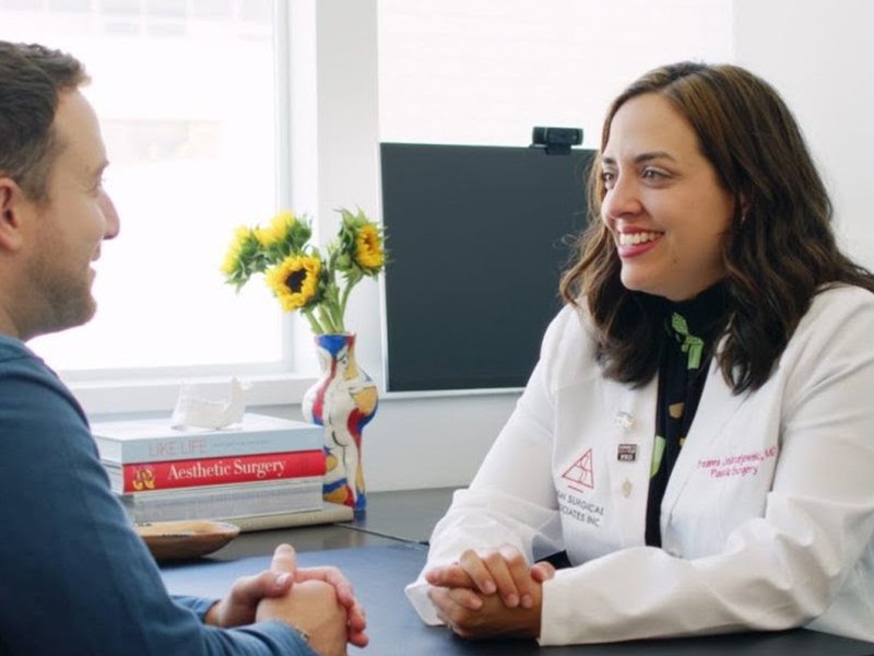 Photo of Dr. Jedrzejewski sitting with a patient