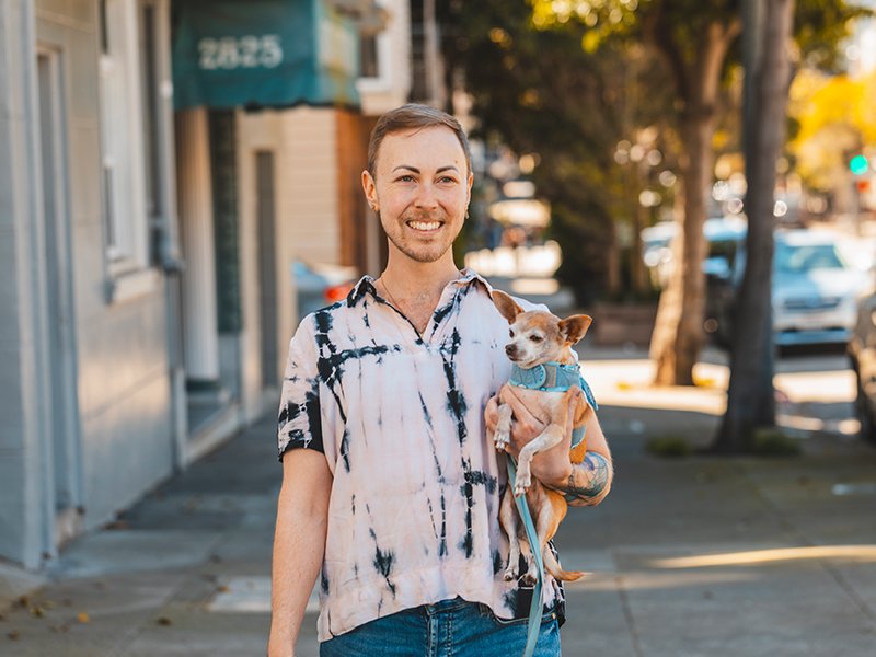 Photo of a smiling patient holding a dog