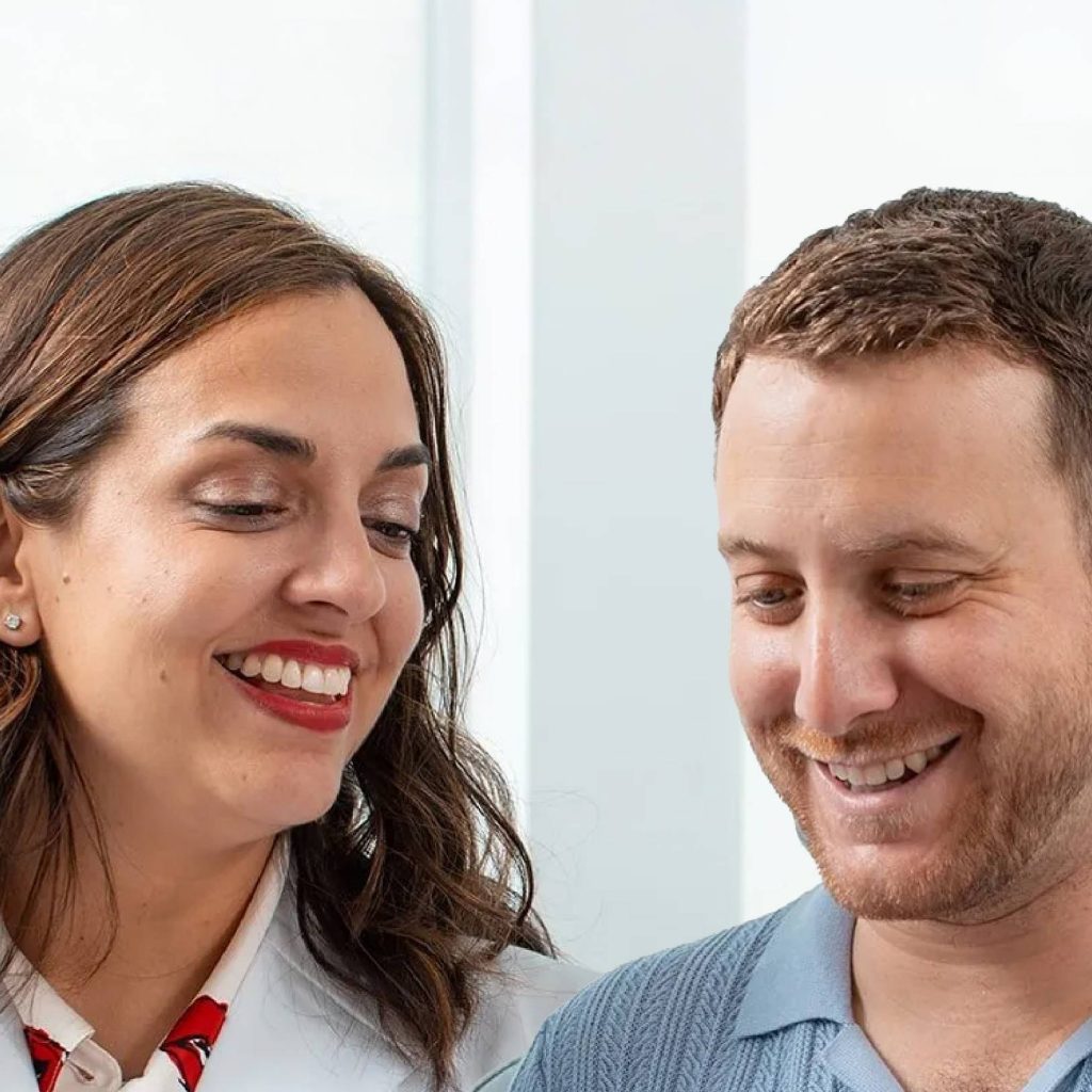 Dr. Jedrzejewski smiling with a patient during a plastic surgery consultation