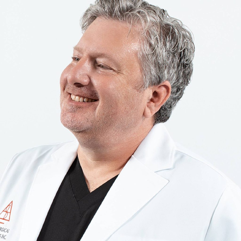 Dr. Safir smiling in a white medical coat