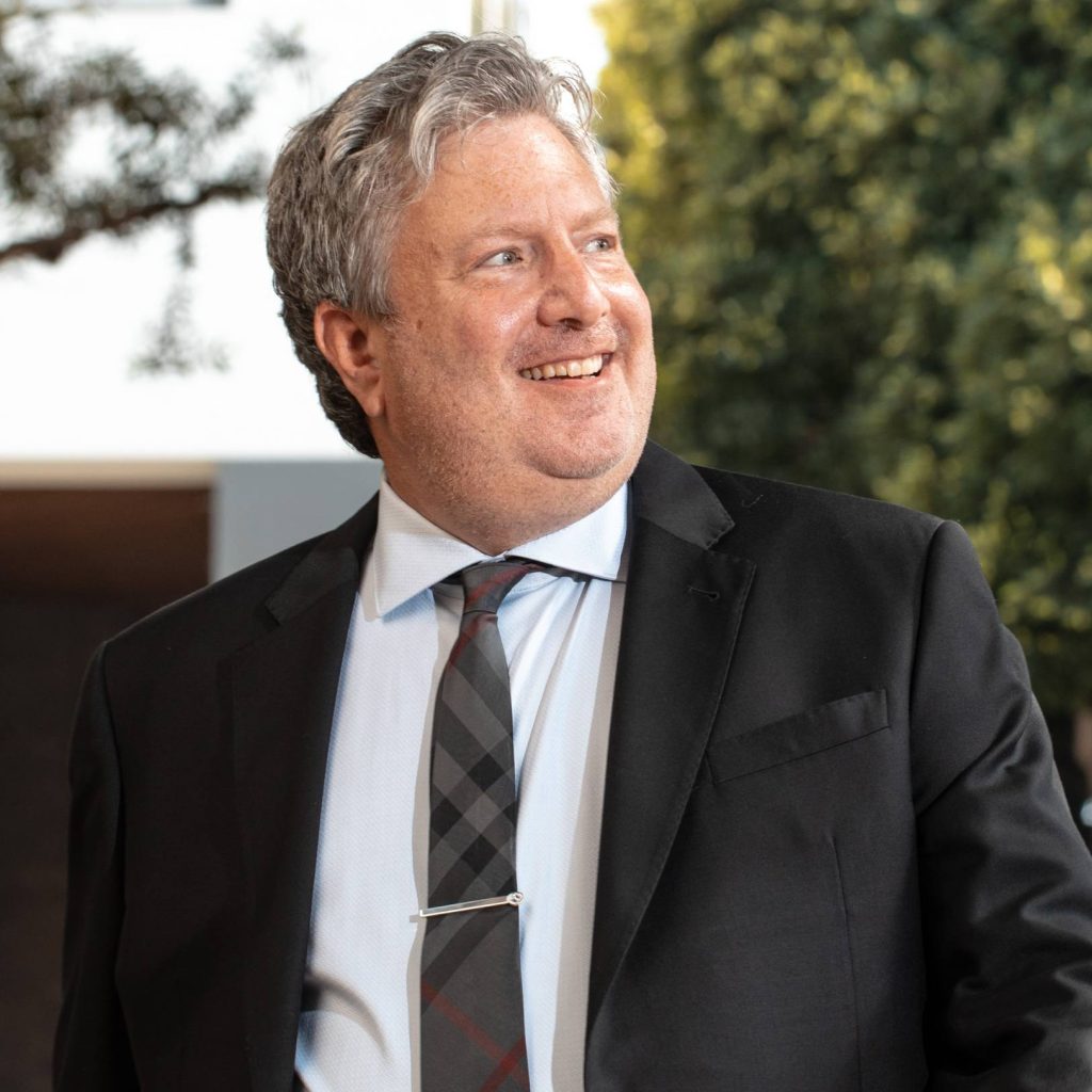 Professional portrait of Dr. Safir in a suit outdoors
