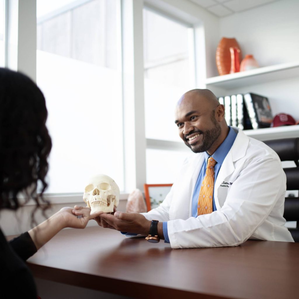 Dr. Satterwhite explaining an anatomical skull model during a consultation
