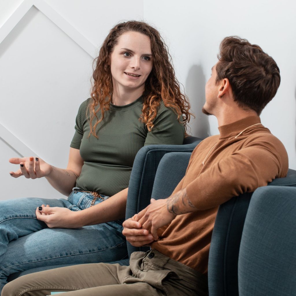 Two patients talking while seated in a consultation room.