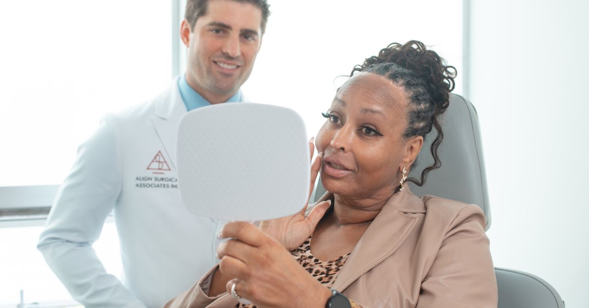Patient looking in a mirror with an Align Surgical Associates doctor standing next to them.