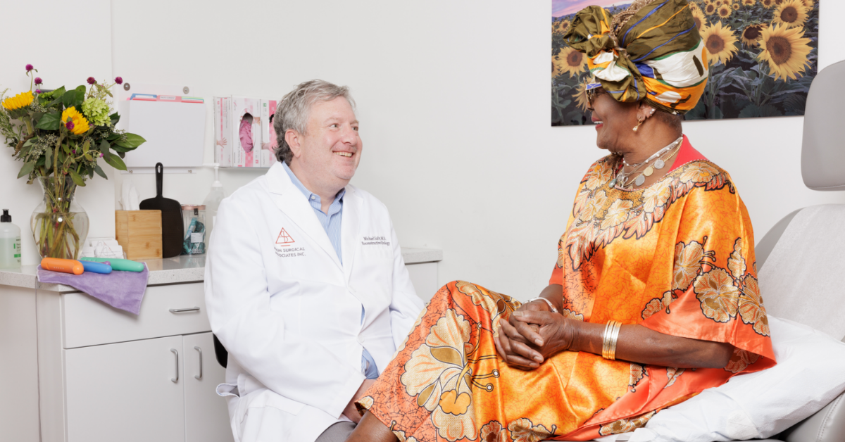 Dr. Michael H. Safir speaking with a patient during a vaginoplasty consultation.